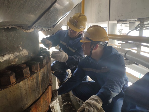 4月6日，機械修造部檢修二部張振華、盧超逸在檢修平臺處，進行4號氣化爐破渣機下降管短節(jié)法蘭螺栓的拆卸工作。.jpg