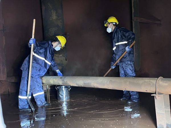 將熱水槽底部污水鏟倒廢桶中，用廢桶搬運出去.jpg