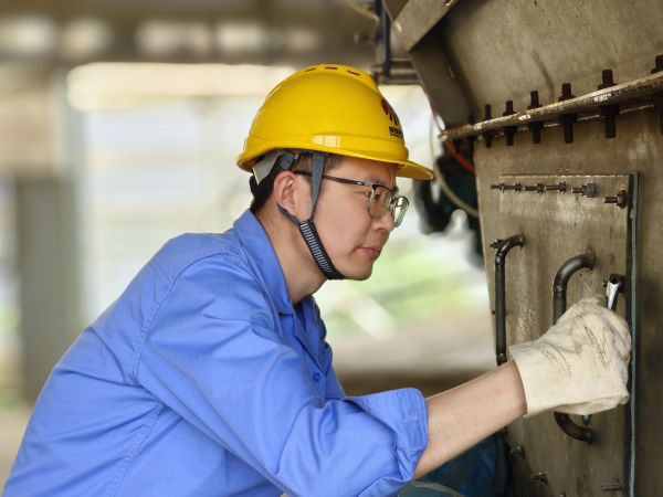 5月11日，尿素車間設(shè)備技術(shù)員馬強(qiáng)檢查設(shè)備螺栓是否松動(dòng).jpg